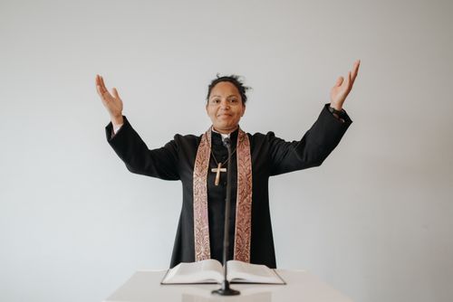 Pastor leading worship with an open Bible